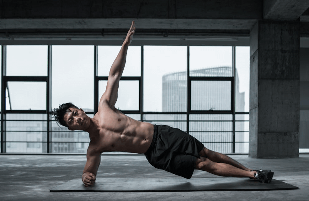 15-Minute Ab Workout for Insane Core Strength 2 man doing side plank in high rise, with city scenery in the background