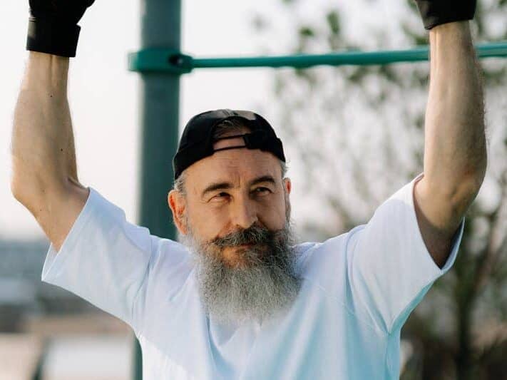 Unlock Calisthenics Strength: 3 Calisthenics Routines 13 image of a man resting underneath a pullup bar